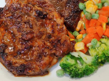 Dilimlenmiş organik domuz eti, çeşitli rengarenk sebzelerle süslenmiş biftek, ahşap masada beyaz tabakta servis edilen bezelye aromalı limon sosu, sokak yemekleri restoranının ünlü gizli tarifi, yemek stilisti.