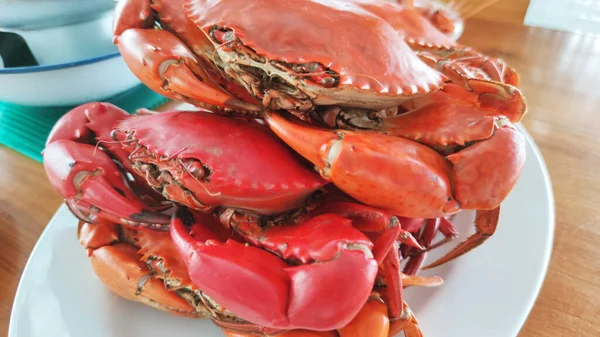 group of boiled stone Crab body builder. Cheliped of the crab serving on light blue plate, prepared raw shell animal at homemade gourmet restaurant, food stylist menu backgrounds