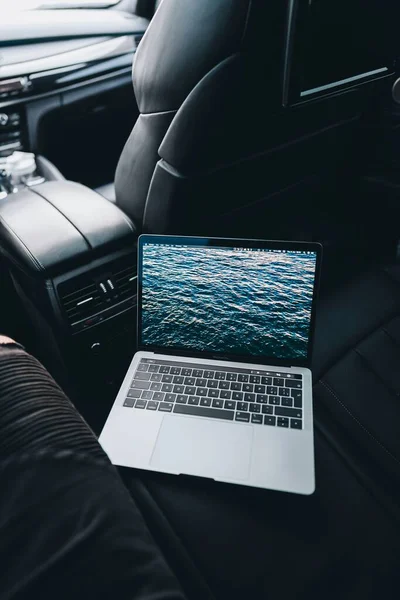 Working at the computer in the car on a laptop