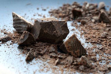 Masada kırılmış siyah acı çikolata parçaları.