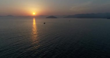 Hava. Kamera deniz altın ve turuncu günbatımı sırasında sinekler. 4k