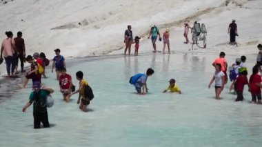 Pamukkale'deki traverten havuzlarını ya da Pamuk Kale'yi ziyaret eden bir turist kalabalığı. Türkiye, Pamukkale, 3 Mayıs 2018.