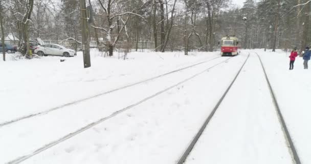 Havadan Çekilen Görüntüler Karla Kaplı Ormanda Kırmızı Elektrikli Tramvay Sürmek — Stok video