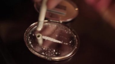 100 dolarlık banknotun içinden aynaya kokain koklamak.