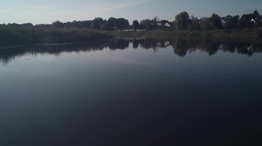 Havadan çekilen görüntüler. Odun teknesinde balıkçı gölde balık yakalar. 4k.