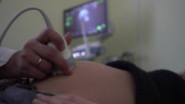 Klinikte hamile bir kadın. Doktor ultrason taramasında bebeğin muayenesini yaptı. 4k.