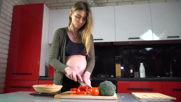 Schwangere Schneidet Gemüse Auf Einem Holzbrett Der Küche — Stockvideo
