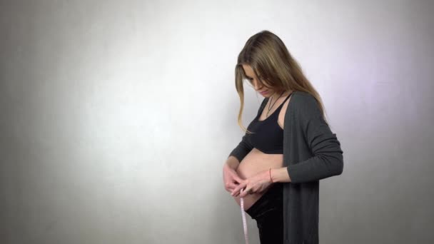 美丽的女人测量她的肚子通过磁带测量 — 图库视频影像