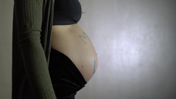 孕妇旋转与在乌萨的铭文在她的肚子上 — 图库视频影像