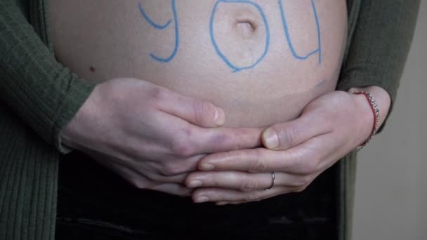 碑文を持つ妊娠中の女性は 私たちは彼女の腹にあなたを愛しています — ストック動画