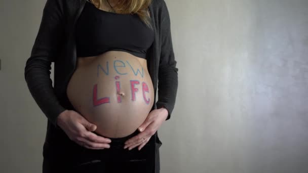 Μια Έγκυο Γυναίκα Μια Επιγραφή Νέα Ζωή Στην Κοιλιά Της — Αρχείο Βίντεο