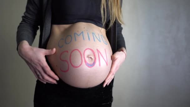 Zwangere Vrouw Met Een Inscriptie Binnenkort Haar Buik — Stockvideo