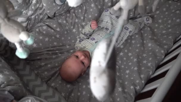 宝宝躺在床上看着旋转的玩具 — 图库视频影像