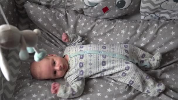 Baby Auf Einem Kinderbett Beim Anblick Eines Sich Drehenden Mobilen — Stockvideo