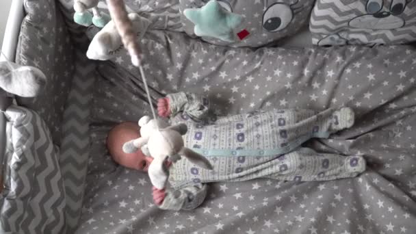 어린이 침대에 아기가 움직이는 이동식 장난감을 있습니다 — 비디오