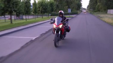 Genç motorcu ülke yolda motosiklet sürme. Sürekli gimbal atış. 4k.