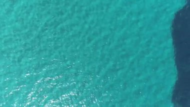 Havadan yukarıdan aşağıya doğru. Sakin mavi deniz suyu arka planı. 4k