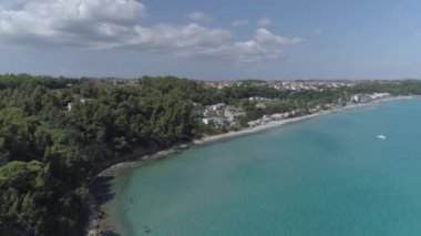 Havadan. Kayalıklarda ağaçlar olan kıyı şeridi. Yunanistan 'da Kallithea plajının yanında. 4k