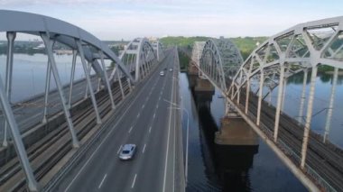 Hava videosu. Ukrayna, Kyiv 'deki modern otomobil ve eski demiryolu köprüleri.