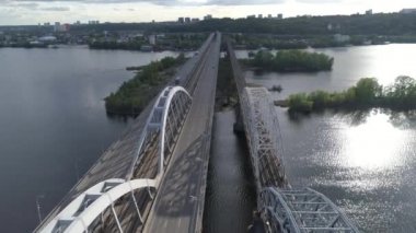 Hava videosu. Ukrayna, Kyiv 'deki modern otomobil ve eski demiryolu köprüleri.