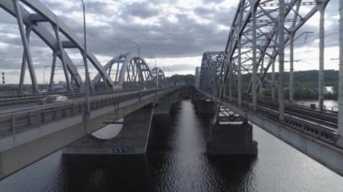 Hava videosu. Ukrayna, Kyiv 'deki modern otomobil ve eski demiryolu köprüleri.