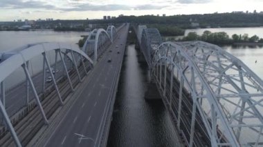 Hava videosu. Ukrayna, Kyiv 'deki modern otomobil ve eski demiryolu köprüleri.