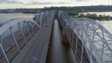 Hava videosu. Ukrayna, Kyiv 'deki modern otomobil ve eski demiryolu köprüleri.