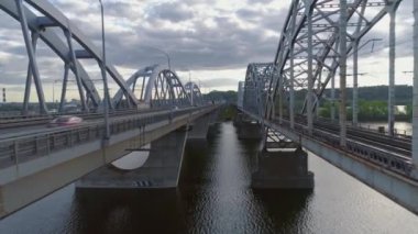 Hava videosu. Ukrayna, Kyiv 'deki modern otomobil ve eski demiryolu köprüleri.