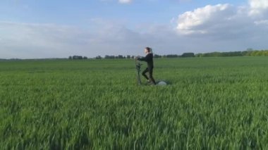 Hava görüntüsü. Yeşil fitness. Genç bir kadın yeşil alanda stepper üzerinde çalışıyor..