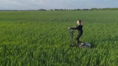 Hava görüntüsü. Yeşil fitness. Genç bir kadın yeşil alanda stepper üzerinde çalışıyor..