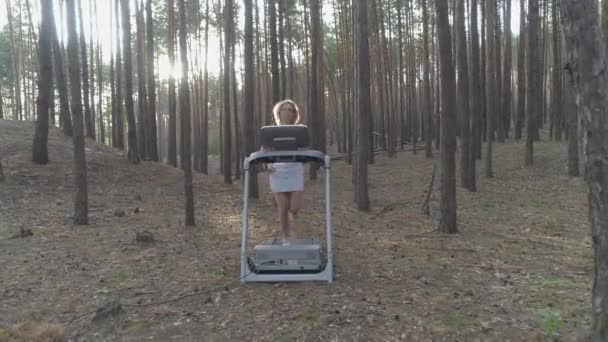 年轻女子在森林里的跑步机上奔跑 — 图库视频影像