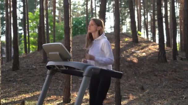 年轻的女运动员在森林里的跑步机上跑步 Dolly Shot — 图库视频影像