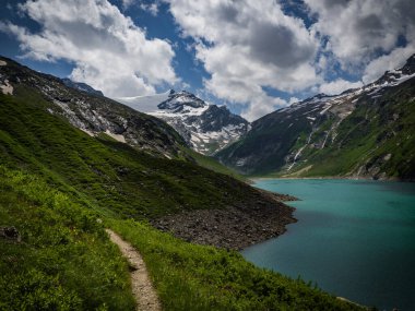 Kaprun, Avusturya, Avrupa yakınlarındaki Mooserboden 'da manzara. Ulusal park Hohe Tauern. Üzerinde inanılmaz renkli su ve buzullar olan büyüleyici bir göl. Tatil için en sevilen yer.