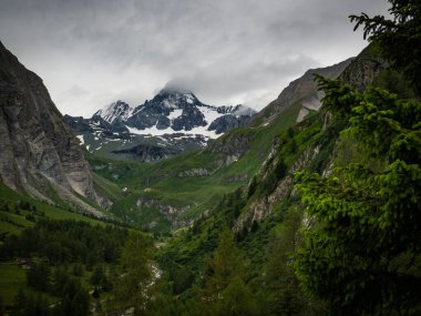 Buzulları karla kaplı Grossglockner Avusturya 'nın en yüksek dağına inanılmaz ve dramatik bir manzara sunuyor. Fırtınadan hemen önce gökyüzü kara bulutlarla dolu. Güzel şehrin yakınında Kals am Grossglockner.