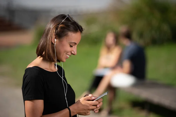 Porträt Eines Lächelnden Brünetten Mädchens Das Auf Seinem Handy Chattet — Stockfoto