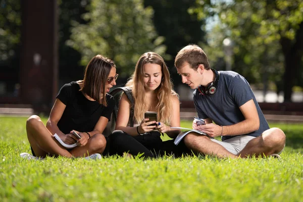 Drei Überraschte College Studenten Schauen Auf Ein Smartphone Während Sie — Stockfoto