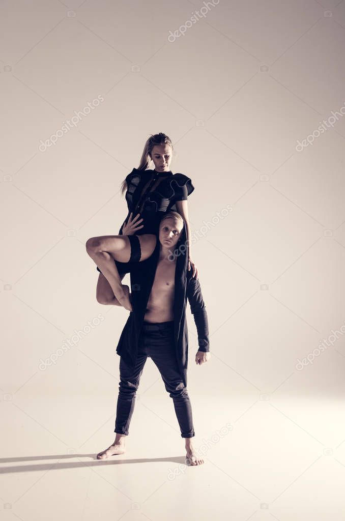 young acrobat sensual dancers on empty background 