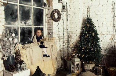 Noel oturan güzel küçük kız pencere ve tahta at tutan dekore edilmiş 