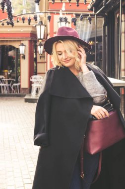 güzel genç kadın whine kırmızı şapka ve gülümseyen, siyah sonbahar ceket sokak stili 