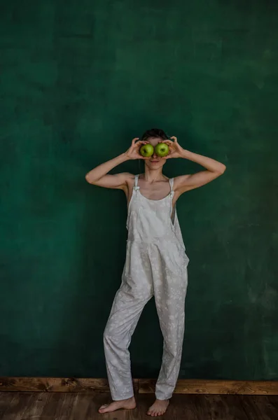 Jonge Vrouw Wit Pak Poseren Holding Appels Groene Muur Achtergrond — Stockfoto