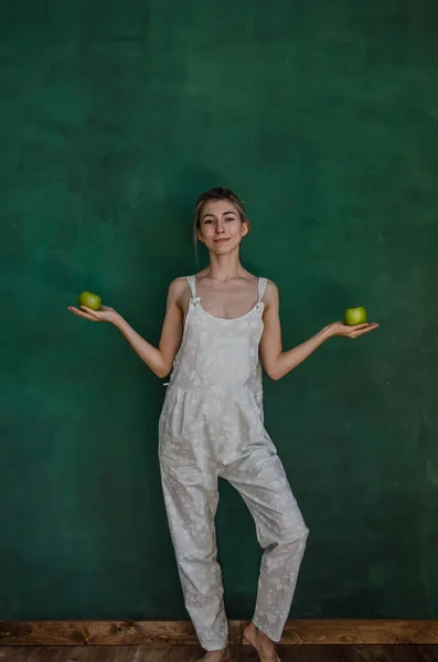 Mujer Joven Traje Blanco Posando Sosteniendo Manzanas Sobre Fondo Pared —  Fotos de Stock