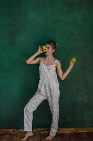 Jonge Vrouw Wit Pak Poseren Holding Appels Groene Muur Achtergrond — Stockfoto