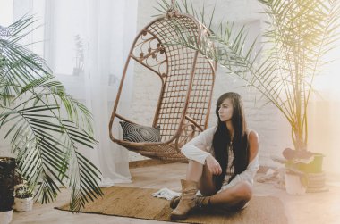 şehvetli kadın beyaz şort ve avuç içi ve hasır sallanan sandalye, boho stil yakın oturan üst