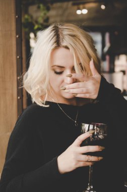 Güzel genç çekici kadın cafede oturan ve kırmızı şarap içme