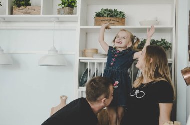mutlu genç aile hamile kadın ve İskandinav mutfakta oturuyor ve having fun küçük kız