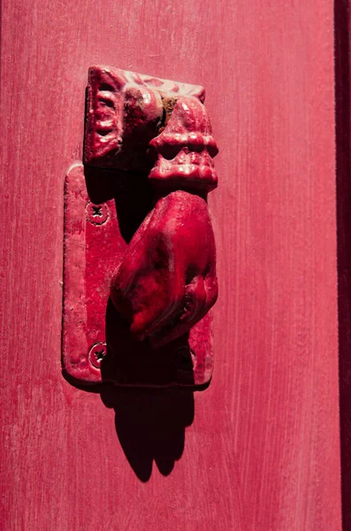 old hand knock on red wooden door