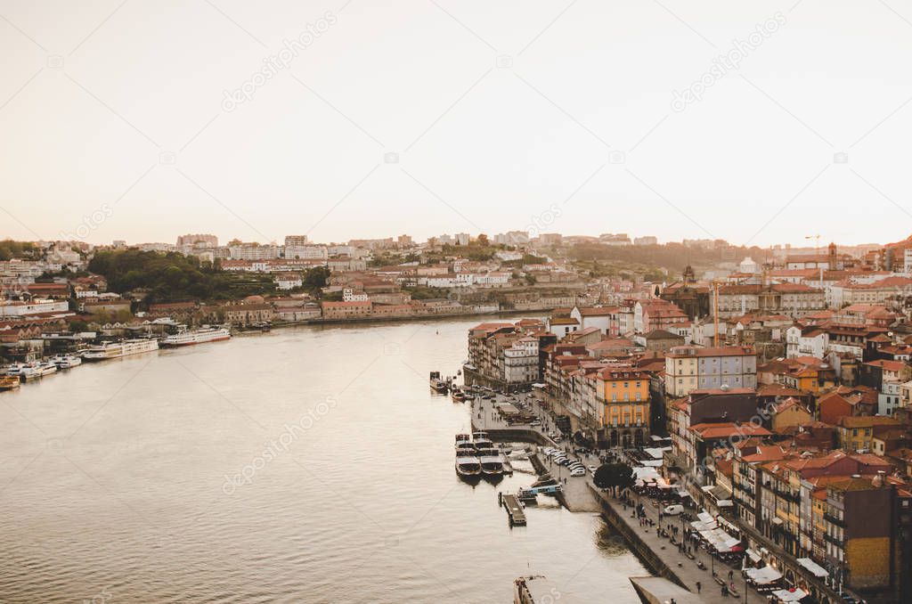 beautiful Porto cityscape with red roofs, boats and river while sunset 