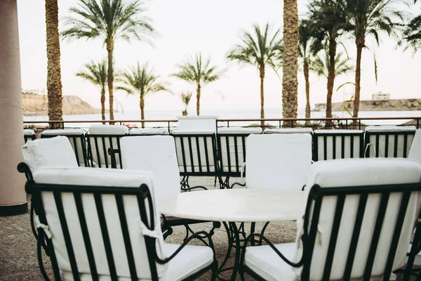 Sillas blancas y mesa al aire libre con vista al mar — Foto de Stock