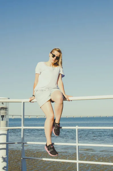 Jovem mulher sentada perto do oceano e olhando para a frente — Fotografia de Stock