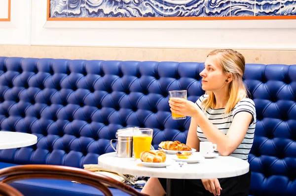 Junge Frau frühstückt und trinkt frischen Saft — Stockfoto
